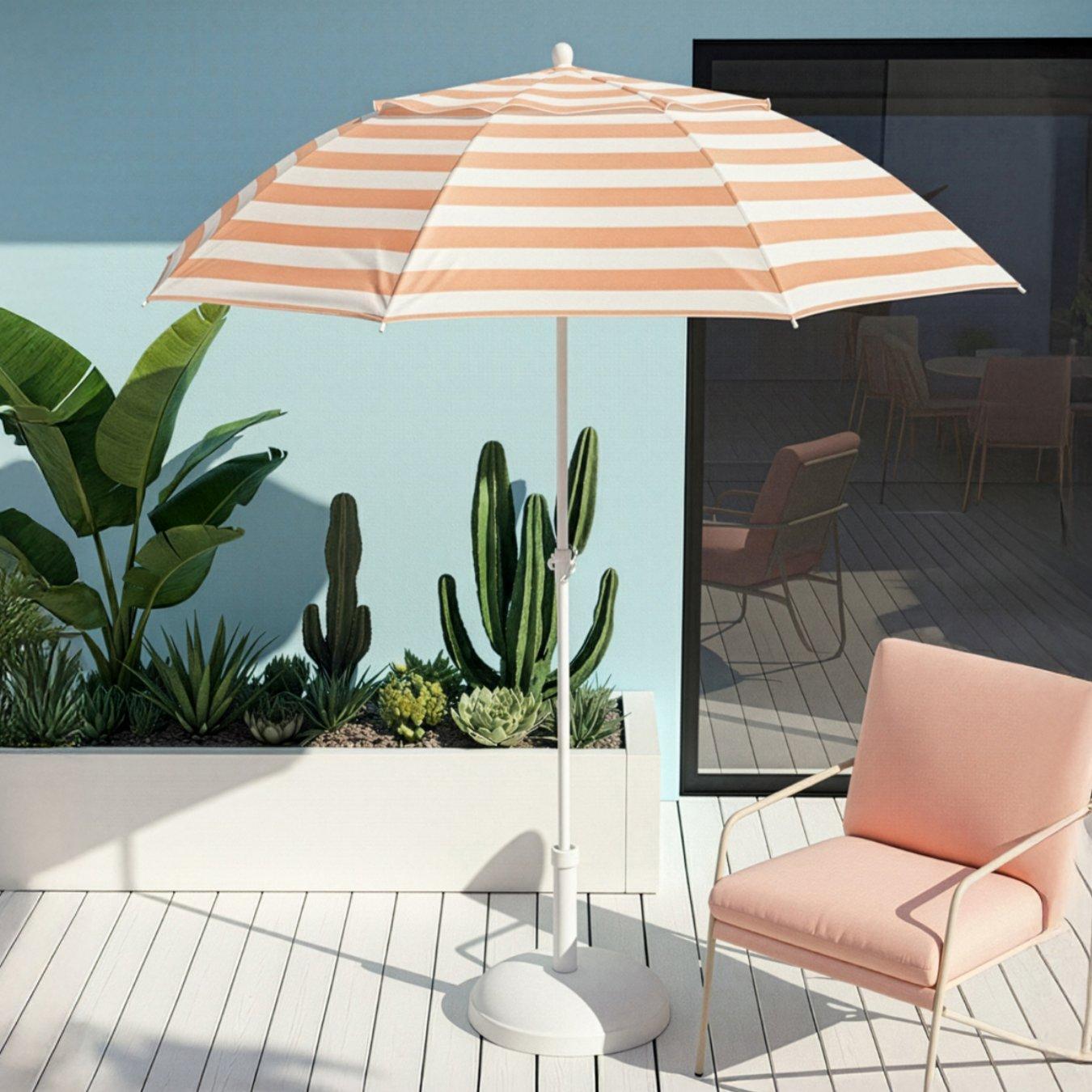 An orange and white striped parasols stands open on a white deck with a matching orange chair underneath it.
