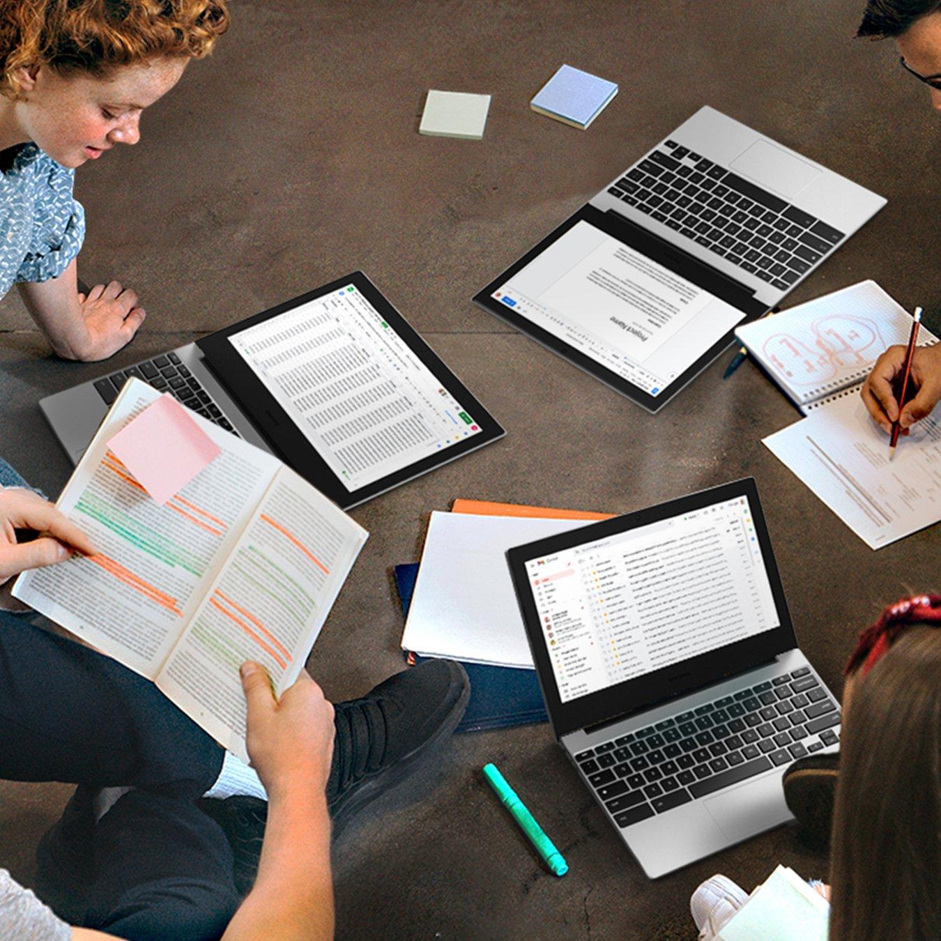 Students working together in a focus group. They have 2-in-1 laptops, notebooks and sticky notes dotted all over the scene.