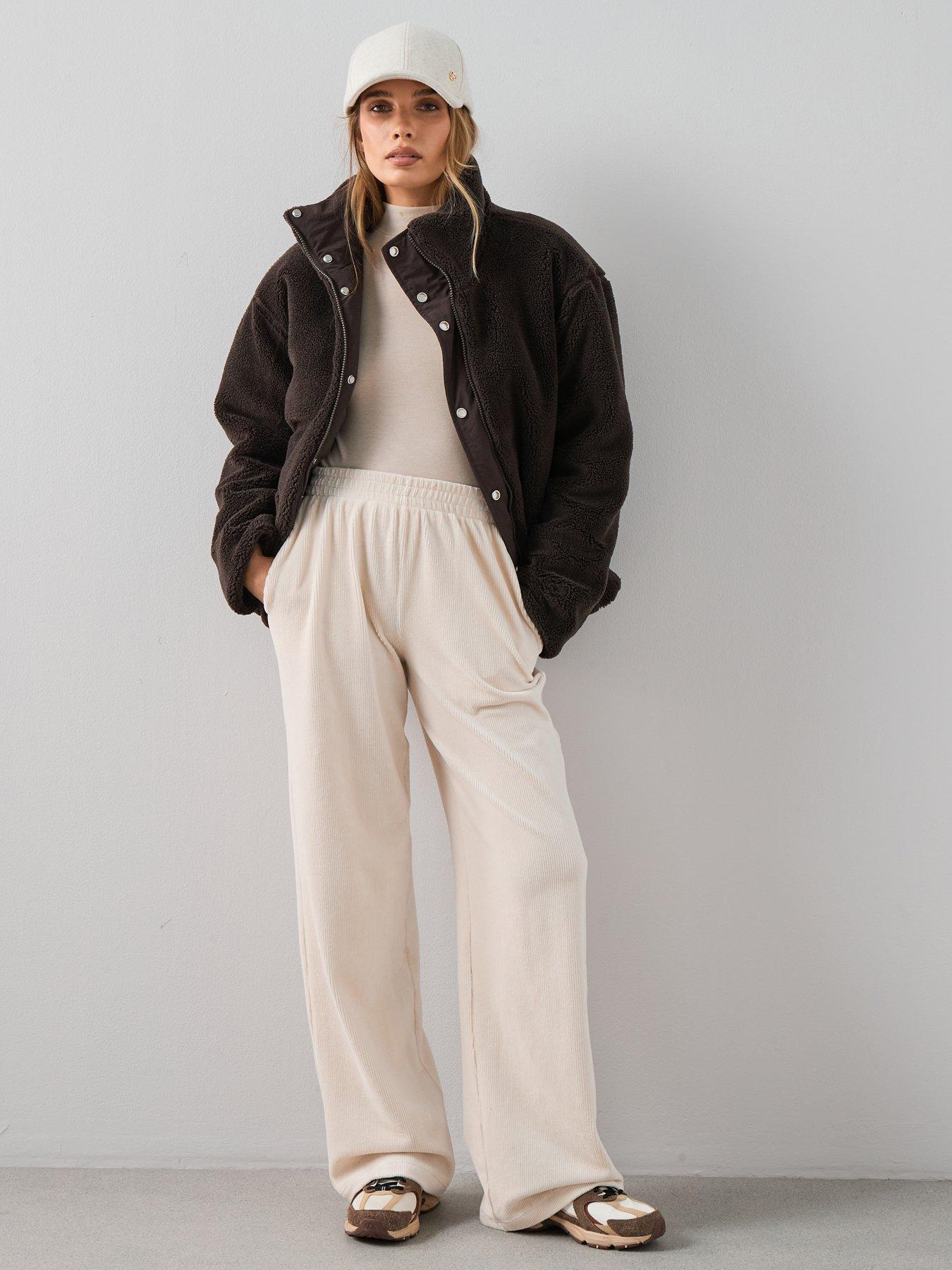 Activity date outfit consisting of cream wide leg trousers, a plain t-shirt, borg jacket and trainers.