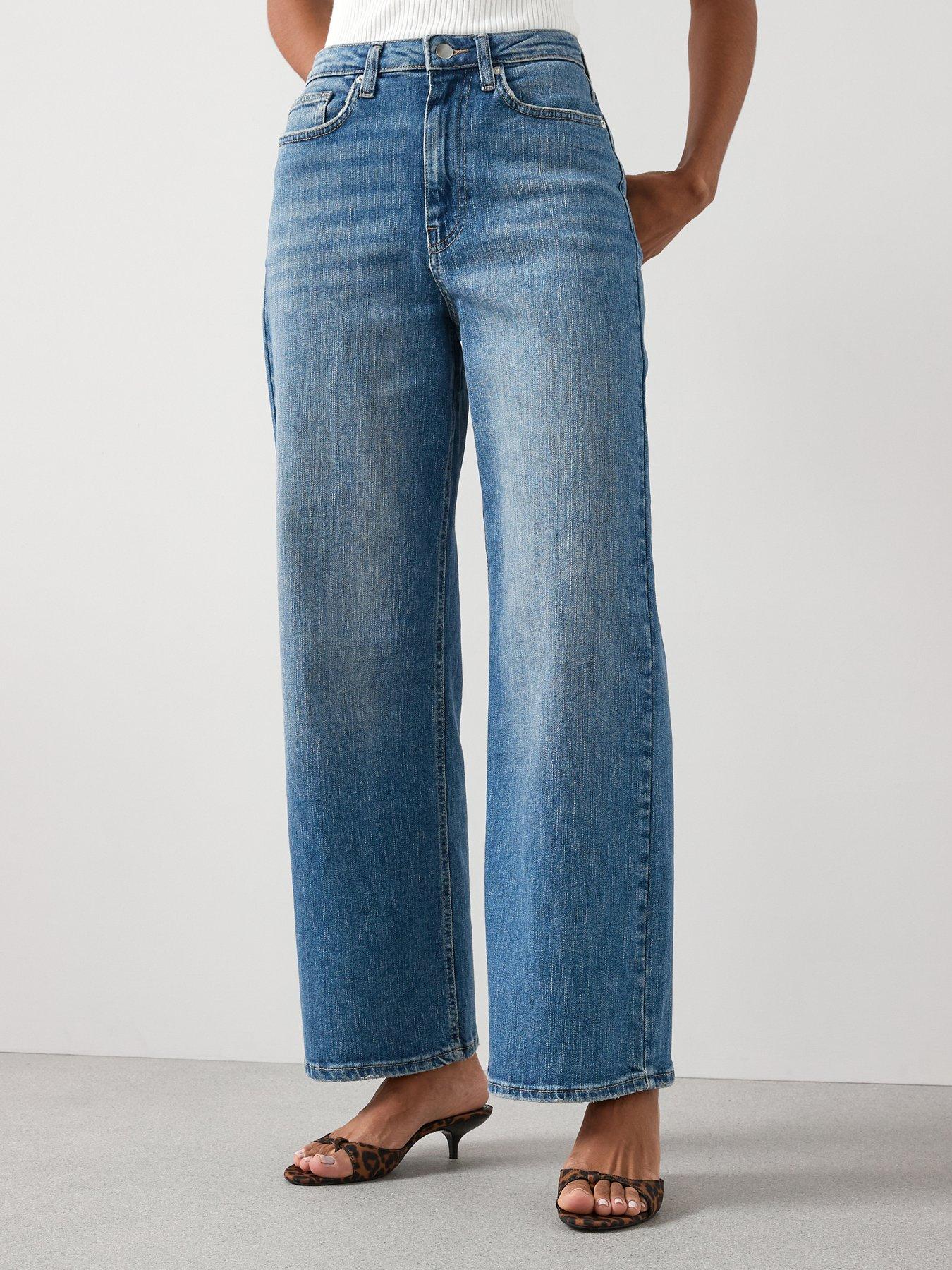 Model wearing a pair of light wash denim jeans in a wide leg style 