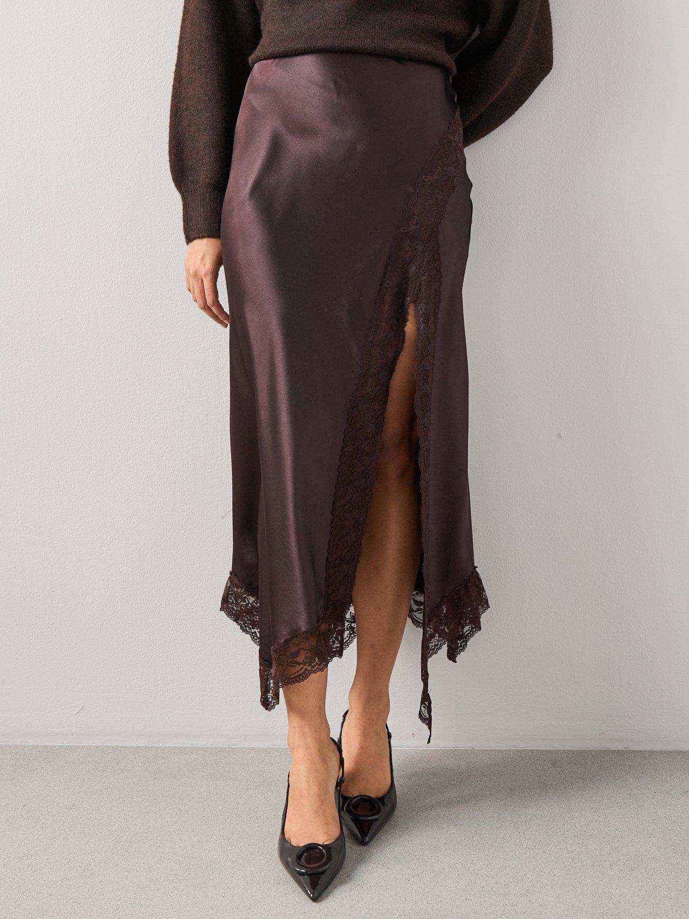 Model wearing a chocolate brown satin midi skirt with lace trim paired with a chocolate brown pair of low court heels.