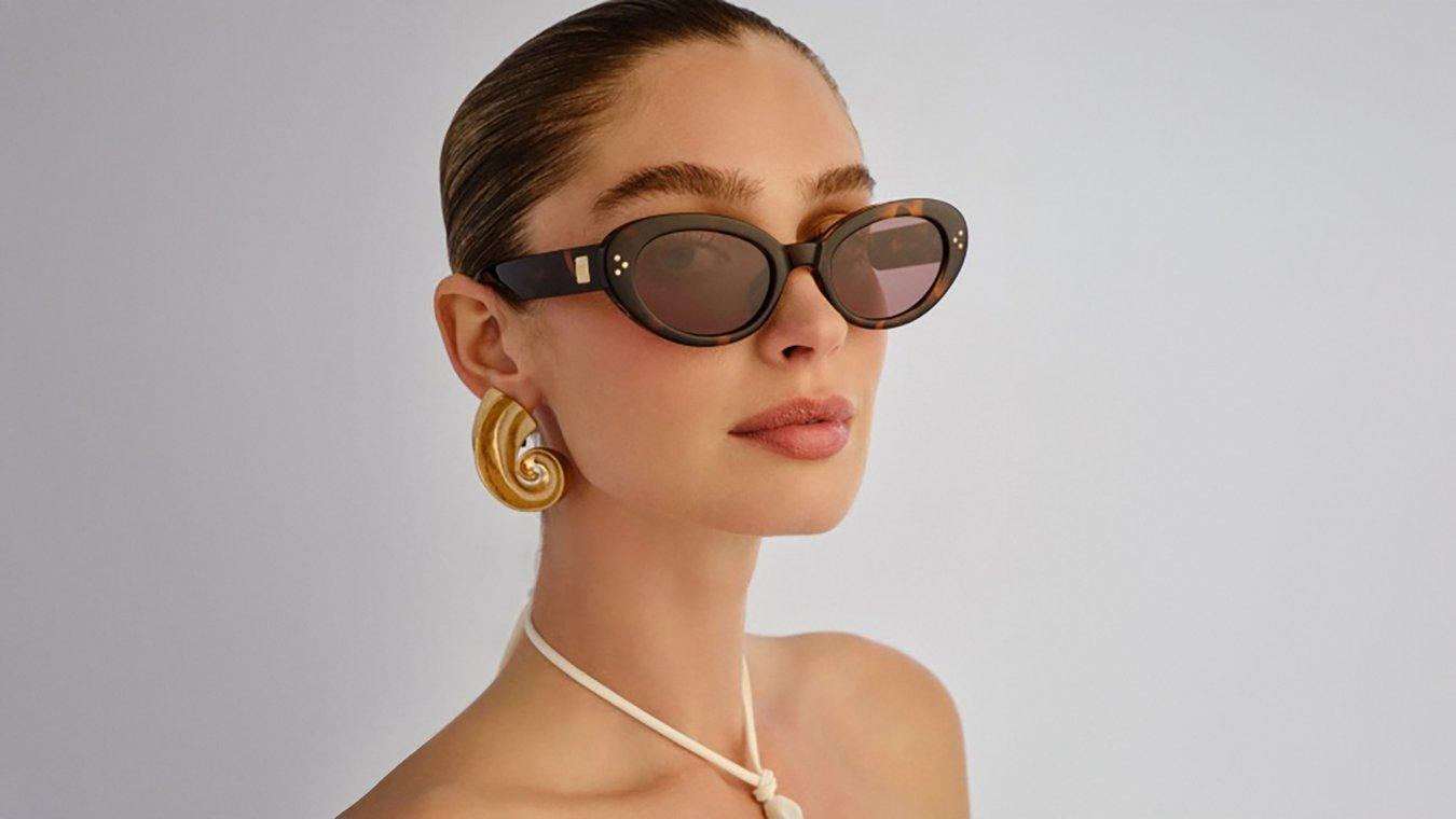 A woman with a diamond face shape wearing a pair of oversized, rounded sunglasses.