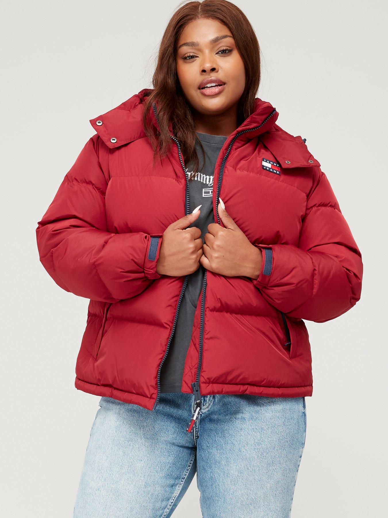 Cropped view of woman wearing red tights and grey jacket on red background  - Stock Photo - Dissolve